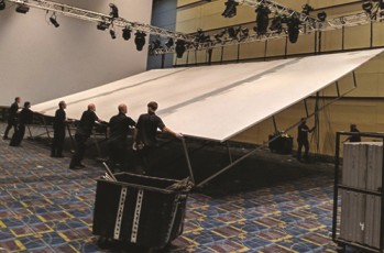 Seamless white AV-Drop Modular Backdrop being setup on rig in ballroom for corporate event